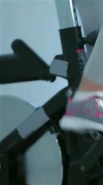 Bu canlandırıcı yakın plan, canlı renklerle dolu canlı bir spor salonunun arka planına kurulmuş, hareketsiz motorlar üzerinde enerjik bir şekilde pedal çeviren atletik ayakların yoğun hareketini yakalıyor. Görüntü kararlılık ve canlılık yayıyor.