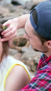 Genç bir adam, arkadaşlarının saçlarını sevgiyle tarar. Titreyen suların kenarında, pürüzsüz, güneşten öpülmüş taşlarla çevrili neşeli bir anı paylaşırlar. Bu iç açıcı sahne, dostluğun, kahkahanın ve...