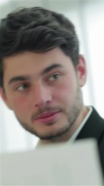 Sivri takım elbiseli üç dinamik işadamı, özgüven ve dostluk saçan şık, çağdaş bir ofis masasında fikir alışverişinde bulunuyorlar. Onların parlak gülümsemeleri ve coşkulu jestleri ilham verici bir işbirliği atmosferi yaratıyor.