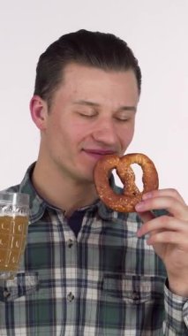 Neşeli genç bir adam gururla mutluluk saçar bir elinde soğuk bir bardak bira, diğer elinde de altın, yumuşak bir çubuk kraker tutarken. Şık ekose gömleği, kutlama havasını tamamlıyor. Kutlamanın ve hoşgörünün özünü yakalıyor.