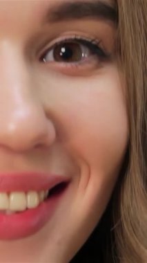 Bu büyüleyici yakın çekim, göz kamaştırıcı bir gülüşü olan neşeli, beyaz bir arka planda ışıldayan parlak teniyle beyaz bir kızı gözler önüne seriyor. Işıl ışıl gözleri ve canlı kırmızı dudakları pozitiflik ve sıcaklık saçıyor. Seyircileri tadını çıkarmaya çağırıyor.