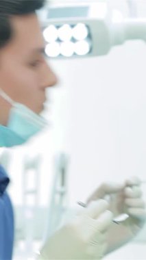 Mavi üniformalı ve koruyucu maskeli, kendini işine adamış genç bir dişçi hastaların dişlerini özel diş aletleri kullanarak dikkatle inceler. Bu samimi sahne, profesyonel diş bakımının önemini vurgular, ve bu karışımın...