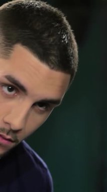 Özenle hazırlanmış sakalı ve modern saç kesimi olan şık bir genç adam klasik bir berber aynasında yansımasını inceliyor. Havası klasik bir cazibe yayıyor, yetenekli berber sakalını ustalıkla şekillendiriyor, erkeklerin zarafetini vurguluyor.