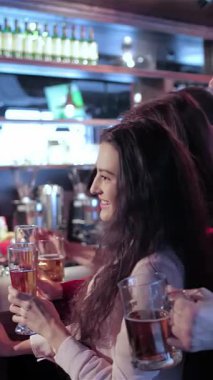 Dört eski arkadaş, iki erkek ve bir kadın renkli ışıkların sıcacık parıltısıyla aydınlanan hareketli bir barda kadehlerini sevinçle kaldırırken canlı bir sahne beliriyor. Bulaşıcı gülümsemeleri ve kahkahaları havayı dolduruyor, en sevdikleri futbolu kutluyorlar.