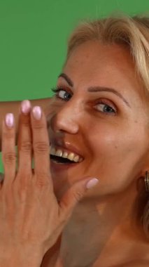 Canlı, yeşil renkli bir arka planı olan canlı bir stüdyoda, çekici, olgun bir kadın şakayla gülüyor, yüzünü eliyle örtüyor. Onun ışıl ışıl gülüşü ve flörtöz tavırları güven ve cazibe saçıyor, izleyicileri onun neşeli ve...