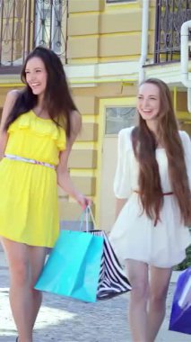 Her biri renkli alışveriş torbalarıyla gösterişli bir sokakta yürürken üç şık genç kadın neşe saçıyor. Kahkahaları ve kaygısız ruhları bulaşıcı bir atmosfer yaratıyor, moda kıyafetlerini ve keyifli bir heyecanı gözler önüne seriyor.