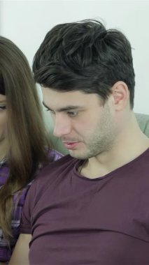 İki neşeli arkadaş, dalgalı kahverengi saçlı genç bir kadın ve şık koyu renk saçlı genç bir adam laptoplarından büyülenmiş rahat bir kanepeye yakın oturuyorlar. Işıl ışıl gülüşleri ve canlı sarı çay fincanları sıcak bir atmosfer yaratıyor.