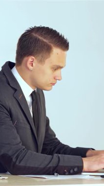 Kendini işine adamış, şık bir takım elbise giymiş genç bir işadamı, verileri parlak dizüstü bilgisayarında yoğun bir şekilde analiz ediyor, profesyonellik ve hırsı somutlaştırıyor. Görevini tamamladıktan sonra kendinden emin bir şekilde cihazı kapattı ve ışıltılı bir gülümseme paylaştı.