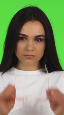 Bu çarpıcı stüdyo portresi, ateşli esmer bir kadını sergiliyor. Seyirciyi büyülüyor. Pembe gözlüklerini canlı yeşil bir arka planda sergiliyor. Kendinden emin duruşu, güç ve gençlik enerjisi yayıyor.