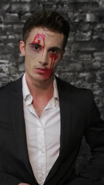 Gösterişli siyah takım elbiseli, çarpıcı bir erkek vampir. Ağzından siyah tuğlalı bir duvara çarpan kanı siliyor. Bu ürpertici görüntü Cadılar Bayramı 'nın özünü özetliyor. Zarafetle korkuyu harmanlıyor. Vampirlerin yoğun bakışları.