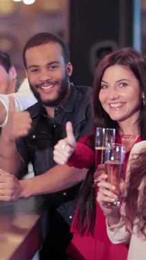 Barda genç erkek ve kadınların coşkulu bir araya gelmesi kadehlerini kaldırırken neşe saçıyor. Heyecanla dolu bu canlı ekip, en sevdikleri futbol takımı için tezahürat yaparken buzlu biraların tadını çıkarıyor.