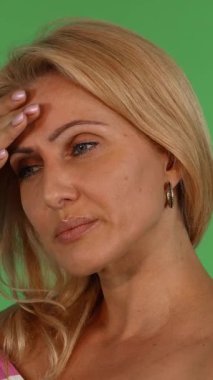 Yetişkin bir kadının dokunaklı portresi dalgalı sarı saçlı, eli alnında dinleniyor, canlı yeşil renkli arka planına karşı zorlu bir çalışma gününün bedelini gösteriyor. Onun yorgun gözleri ve ince kaşları derin empati çağrıştırıyor.