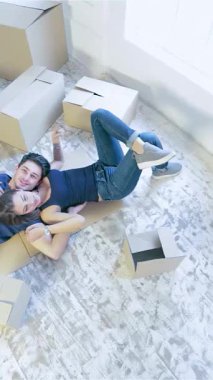 Kutularla dolu, aydınlık, havadar bir dairede bir çift yerde sevgi dolu, neşe ve sıcaklık saçan bir şekilde yatıyor. Işıldayan gülümsemeleri ve rahat kıyafetleri yeni maceralarına atılmanın heyecanını yakalıyor.