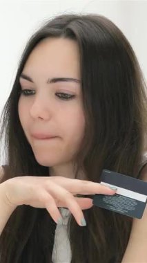 Elinde kredi kartı bulunan odaklanmış genç bir kadın, etkin bir şekilde stratejilerini tartışan ilgili işadamları tarafından çevrimiçi alışverişe dalmış durumda. Bu canlı sahne dijital ticaretin ve profesyonel sinerjinin heyecanını yakalıyor.