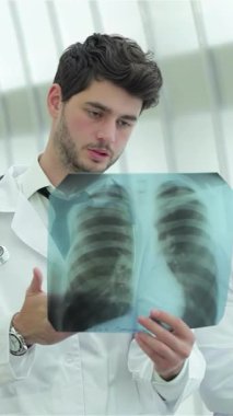 Kendini işine adamış üç doktor, iki erkek ve bir kadın, sigara içmenin tehlikeleriyle çelişen sağlıklı akciğerlerin röntgenini titizlikle inceliyorlar. Gıcır gıcır beyaz önlükleri ve yoğun dikkatleri profesyonellik atmosferi yaratıyor.