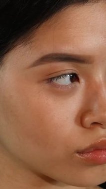 Kendine güvenen genç bir Asyalı kadının çarpıcı yakın çekimi dudak piercingli, ışıl ışıl gülüşü ve canlı yeşil renkli bir arka plana karşı büyüleyici kaşlarını kaldırdı. Parlak cildi ve anlamlı gözleri neşe ve canlılık saçıyor.