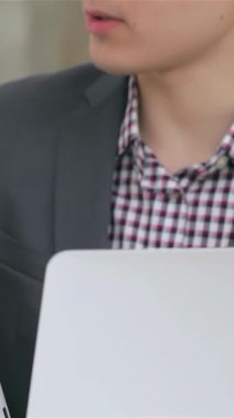 Yakın planda, modern bir tablette hayati verileri tartışan genç, şık bir iş kadını ve işadamının dinamik elleri görülüyor. Çağdaş bir ofis arkaplanına dayanan odaklanmış ifadeleri...