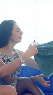 İki neşeli kız arkadaş, birlikte moda keşiflerini yaparken yüzleri heyecanla parlayan muhteşem yeşil bir elbiseden büyülenir. Yumuşak, doğal ışık onların canlı gülümsemelerini ve elbisenin zarif dokusunu arttırır.