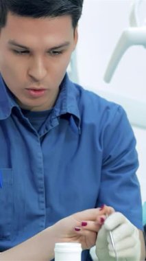 Parlak ve modern bir dişçi kliniğinde, dişlerini dikkatlice incelerken dişlerini titizlikle hazırlayan genç bir dişçiye rehberlik eder. Bu canlı sahne dişçilikte akıl hocalığının özünü yakalar.