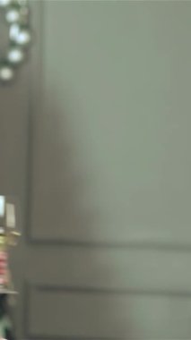 Hoş, güzel dekore edilmiş bir Noel odasında şık kazaklar ve şenlikli eşarplar giyen neşeli bir çift şampanyayla kadeh kaldırırken tutkulu bir öpücük paylaşıyor. Noel ağacının büyüleyici parıltısı ve parıldayan ışıklar onları sarıyor.