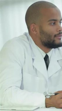 Parlak ve modern bir hastanede, beyaz önlüklü şefkatli bir doktor bir hastayla anlamlı bir konuşma yapar, güven ve anlayışı arttırır. Bu sıcak etkileşim, sağlık hizmetlerinde iletişimin hayati önemini vurgular.