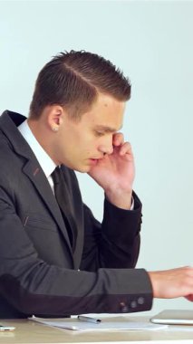 Sivri takım elbiseli odaklanmış genç bir işadamı, notları not alıp bir telefon görüşmesine girerken, ince bilgisayarındaki verileri dikkatle analiz ediyor. Bu canlı sahne, modern kurumsal hayatın çabukluğunu özetliyor.