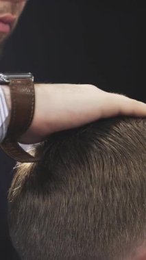 Büyüleyici bir yakın planda, yetenekli bir berber, titiz bir makas kullanarak bir müşterinin saçını ustaca şekillendirir, klasik bir berber dükkanında tımarcılık sanatını sergiler. Sahne profesyonellik ve adanmışlık içeriyor, berberleri vurguluyor.