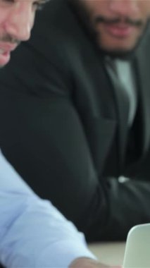 Doğal ışıkla dolu çağdaş bir ofiste, iki kararlı işadamı parlak bir dizüstü bilgisayardaki renkli raporları analiz ederken stratejik hedeflerini tutkuyla tartışıyor. Keskin resmi kıyafetleri ve yoğun dikkatleri profesyonellik saçıyor.