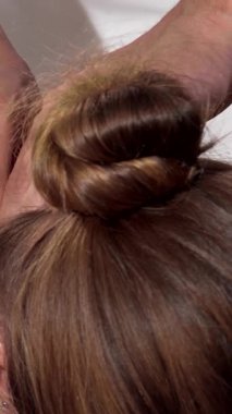 Huzurlu bir spa sahnesinde, bir kadın zevkle sırt masajı yaptırıyor, becerikli elleri boynunu ve omuzlarını nazikçe yoğuruyor. Yumuşak mum ışığının sıcacık parıltısı ve gerekli yağların sakinleştirici kokusu davetkar bir atmosfer yaratır.