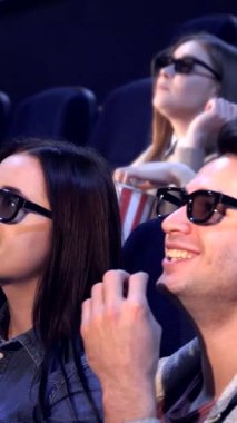 Canlı bir yetişkin grubu, şık 3D gözlükler takmış, loş bir tiyatro içinde büyüleyici bir film sahnesinde eğlenirken kahkahalar içinde patlıyor. Patlamış mısır ve ışıl ışıl gülücükler dağıtırken hava neşe ve yoldaşlıkla uğulduyor.