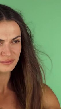 Akan, ipek gibi saçları olan ışıl ışıl genç bir kadın kendine güvenle gülümserken saçlarını ustalıkla kurutuyor ve çarpıcı yeşil renkli bir arka plana yaslanıyor. Bu dinamik sahne, onun zarafetini vurgulayan güzellik ve kendine bakmanın ruhunu somutlaştırıyor.