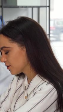 Gösterişli, çağdaş bir ofiste, iki genç bayan tasarımcı bir dizüstü bilgisayar üzerinde işbirliği yaparken tutkulu bir şekilde beyin fırtınası yapıyorlar, yaratıcılığı ve takım çalışmasını somutlaştırıyorlar. Şık kıyafetleri ve odaklanmış ifadeleri yeniliğin canlı atmosferini aydınlatıyor.