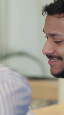 İki neşeli arkadaş canlı bir sohbete dalarlar. Kahkahaları sıcak ışıklarla dolu sıcak bir barda yankılanır. Bir adam, şık bir sakalı ve parlak bir gülümsemesi olan, hareketli bir şekilde, arkadaşlığın keyfini içki içerek kutluyor.