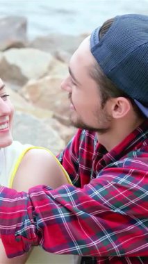 Neşeli bir üçlü genç arkadaş dalgalı su kenarında neşeli bir anı paylaşıyorlar, alınları hafifçe birbirine dokunuyor kahkaha ve sevgiyle. Bu canlı sahne arkadaşlığın ve kaygısız yaz günlerinin özünü özetliyor.