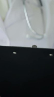 Parlak ve modern bir klinikte, kendini işine adamış beyaz önlüklü bir doktor bir hasta ile tamamen meşgul olan bir reçete yazar. Bu sahne, sağlık hizmetlerindeki şefkatli bağı, profesyonelliği ve destekleyiciliği güzel bir şekilde gözler önüne seriyor.