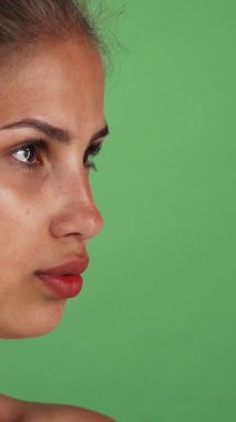 Bu çarpıcı stüdyo portresi kendine güvenen, pırıl pırıl cildi parlak genç bir kadını canlı yeşil bir arkaplan karşısında zarif bir şekilde çerçeveletiyor. Onun yoğun bakışları ve doğal güzelliği sağlık ve canlılık, ilham verici hayranlık ve bir his yayar.