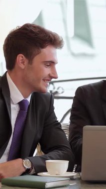 Gülümseyen bir kadın ve iki erkeğin yer aldığı canlı bir iş adamı üçlüsü şık bir restoran masasında fikirleri canlı bir şekilde tartışıyor. Doğal ışıkla yıkandılar ve zarif dekorlarla çevrelendiler. Kahveyi yudumladılar, işbirliği ruhunu somutlaştırdılar.