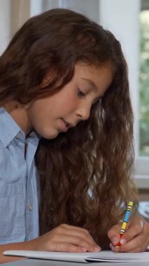 Uzun, dalgalı saçları olan düşünceli genç bir kız kendini okuldaki sanat projesine kaptırırken eli çenesinde dinlenirken hayallere dalıyor. Canlı sanat malzemeleriyle çevrelenmiş, çocukluk yaratıcılığının özünü yayıyor ve