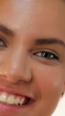 Kıvırcık saçlı, neşe ve pozitiflik saçan parlak, dişlek gülüşünü sergileyen göz kamaştırıcı bir genç kadın. Parlak cildi ve ışıl ışıl gözleri her ayrıntıda güzelliği ve güveni somutlaştıran davetkar bir atmosfer yaratıyor.