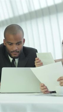 Gösterişli, çağdaş bir ofiste, dört kendine güvenen işadamı, cilalı bir masa etrafında ateşli bir tartışmaya girişiyor, dostluk ve işbirliği sergiliyorlar. Coşkulu ifadeleri ve profesyonel kıyafetleri ışık saçıyor.