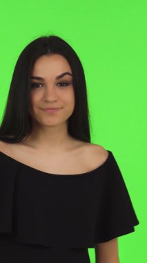 Göz kamaştırıcı esmer, parlak bir taç takan genç bir kız zarif yeşil renkli bir arka plana karşı zarafetle poz verirken zarafet ve kendine güven saçıyor. Bu büyüleyici balo kraliçesi gençliğin ve kutlamaların ruhunu temsil ediyor.