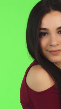 Pürüzsüz, koyu renk saçlı, çarpıcı yeşil bir fon karşısında sevinçle gülümseyen göz kamaştırıcı bir genç kadın. Bulaşıcı mutluluğu pozitiflik ve güven yayar, izleyicileri kendini ifade etmeye ve güzelliği kucaklamaya davet eder.