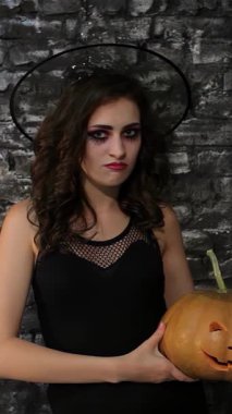 Gösterişli siyah kıyafetli büyüleyici bir büyücü, koyu renkli tuğla bir duvara dayanmış, yaramaz oyulmuş bir balkabağı tutuyor. Cadılar Bayramı 'ndan esinlenilmiş bu sahnede büyüleyici bir gizem ve sihir havası yayılıyor.