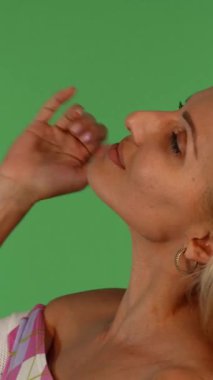 Neşeli, olgun bir kadın saçlarını zarifçe kıvırır, canlı yeşil renkli bir arka plana karşı kendine güven ve cazibe saçar. Bu büyüleyici portre onun zarif özelliklerini ve neşeli ruhunu vurguluyor, her oyuncu güzelliği ve canlılığı somutlaştırıyor.