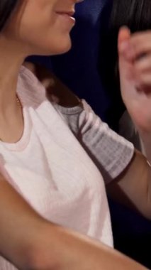 Canlı bir sahnede kahkaha atan, patlamış mısır paylaşan ve sinemadaki komedi filminin keyfini çıkaran üç genç kadın görülüyor. Bulaşıcı gülümsemeleri ve gevşemiş titreşimleri eğlenceli bir hafta sonu için mükemmel bir ortam yaratıyor.