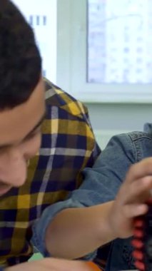 Coşkulu bir Afrikalı Amerikalı baba ve küçük oğlu canlı bir oyuncak olan ATV 'yi incelerken keyifli bir anı paylaşıyorlar. Parıldayan Noel ışıklarının arka planında, bu iç açıcı sahne aile bağlarının ruhunu yansıtıyor ve