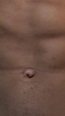 Bu büyüleyici yakın plan, yontulmuş bir erkek gövdesini gözler önüne seriyor, keskin karın kaslarını ve parlak siyah bir arka plana karşı sağlam bir göğsü vurguluyor. Görüntü güç ve adanmışlık yayıyor, insan fiziğinin sanatını ve bağlılığını kutluyor.