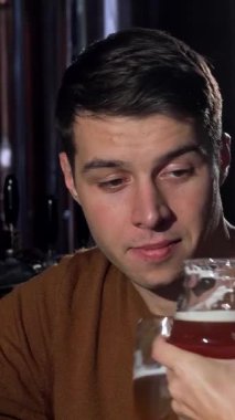 Neşeli bir kadın, kameraya ışıldarken mutluluk saçar erkek arkadaşı da yanında sıcak bir barda serinletici bir bira yudumlar. Bu canlı sahne aşkın ve bağlantının özünü özetliyor. Yıldönümlerini ya da romantizmi kutlamak için mükemmel.