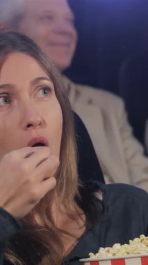 Heyecandan gözleri şişmiş orta yaşlı bir kadın, çeşitli izleyicilerle dolu canlı bir sinemada bir kova patlamış mısırdan hoşlanıyor. Atmosfer heyecan verici, kahkaha ve neşe dolu. Nişanlı seyircilerden yayılıyor. Aralarında iki genç kadın ve...