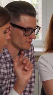 Parlak, modern bir ofiste, profesyonel iş adamlarından oluşan dinamik bir üçlü şık gözlüklü ve iki odaklı genç adam önemli belgelerle ilgili bir animasyon tartışmasına giriştiler. İşbirlikleri enerji ve yaratıcılık yayıyor.